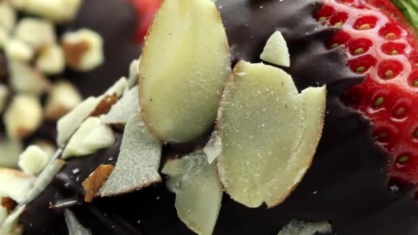 Aardbeien gedoopt in chocolade bedekt met amandel noten — Stockvideo