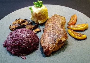 Kırmızı lahana ve orman mantarlı fırında ördek.