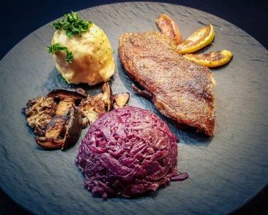 Kırmızı lahana ve orman mantarlı fırında ördek.