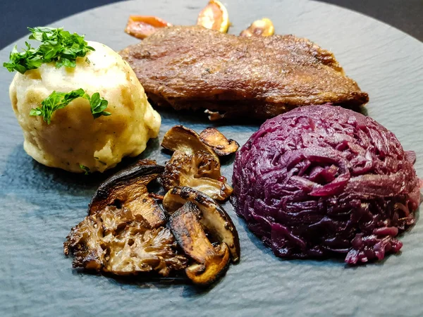 Kırmızı lahana ve orman mantarlı fırında ördek.