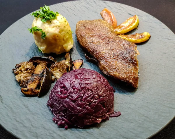 Kırmızı lahana ve orman mantarlı fırında ördek.