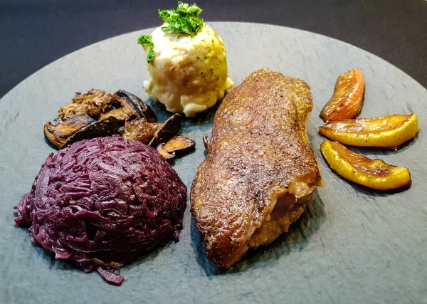 Kırmızı lahana ve orman mantarlı fırında ördek.