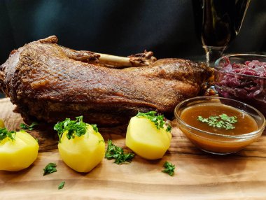 Kızarmış kaz, patates, lahana ve bir kadeh kırmızı şarap.