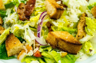 Izgara tavuk pastırmalı geleneksel sezar salatası ve tuzlu sarımsaklı ekmek.