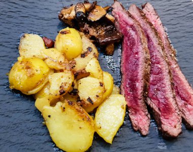 Orman mantarlı biftek ve kızarmış patates.