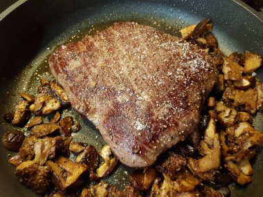 Orman mantarlı biftek ve kızarmış patates.