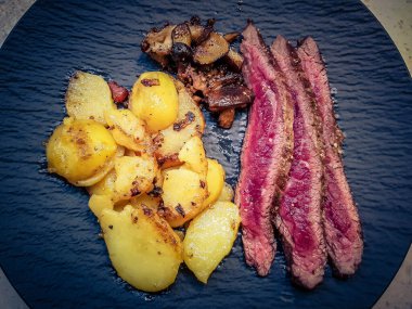 Orman mantarlı biftek ve kızarmış patates.