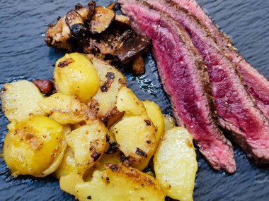 Orman mantarlı biftek ve kızarmış patates.