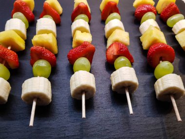 Çikolatayla kaplı bir şişte farklı meyveler.