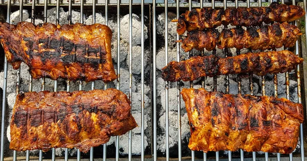 グリルの上のスパイシーなチキンドラムスティックや他の肉 — ストック写真