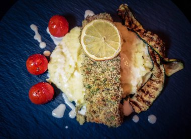 Kızarmış somon bifteği, patates püresi ve kızarmış sebze.