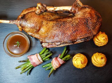 Fasulye ve düşes patatesli kızarmış kaz.