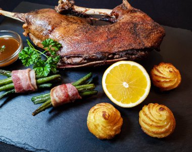 Fasulye ve düşes patatesli kızarmış kaz.