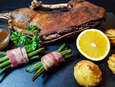 Fasulye ve düşes patatesli kızarmış kaz.