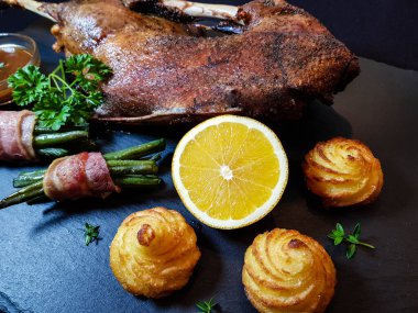 Fasulye ve düşes patatesli kızarmış kaz.