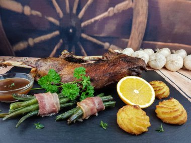 Fasulye ve düşes patatesli kızarmış kaz.