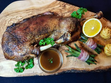 Fasulye ve düşes patatesli kızarmış kaz.