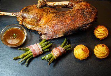 Fasulye ve düşes patatesli kızarmış kaz.