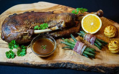 Fasulye ve düşes patatesli kızarmış kaz.