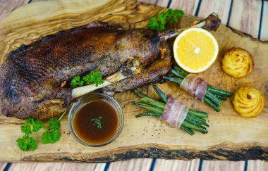 Fasulye ve düşes patatesli kızarmış kaz.