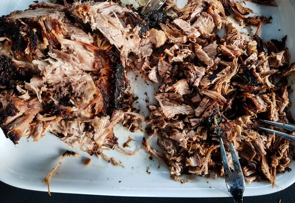 Pulled Pork of a pork shoulder roasted on a smoker