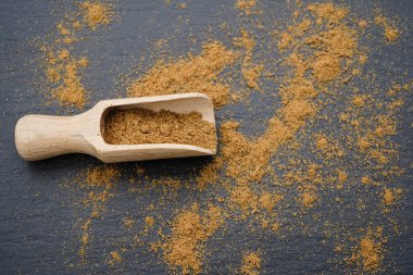 Kahverengi kişniş tozu ve ahşap kaşık
