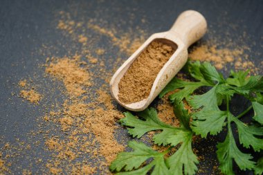 Kahverengi kişniş tozu ve ahşap kaşık