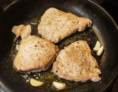 Sarımsaklı ekmek ve salatalı ton balığı bifteği.