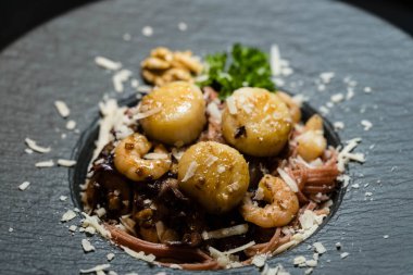 Kırmızı makarna ve baharatlı deniz tarakları.