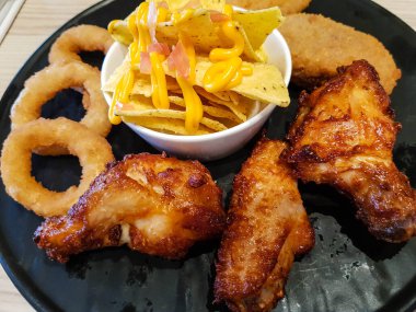 Soğan halkalı tavuk kanadı ve cips.