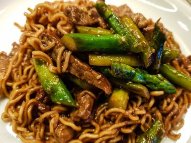 Biftek şeritli Asya eriştesi ve yeşil kuşkonmaz.