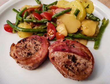 Domuz pastırması ve salataya sarılı domuz filetosu.