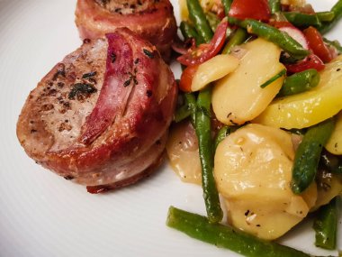 Domuz pastırması ve salataya sarılı domuz filetosu.