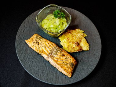 Izgara somon ve patates graten ve salatalık salatası.