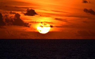 Ufukta güzel bir gün batımı kırmızı, turuncu gökyüzü renginde