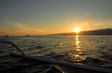 Sabahın erken saatlerinde güzel gökyüzü rengiyle birlikte bir yunus turu sırasında lovina sahilinde güneş doğuyor.
