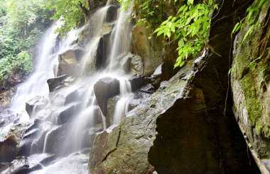 Kanto Lampo Şelalesi Bali Endonezya 'nın Gianyar naipliğinde, berrak su ve siyah kayayla.