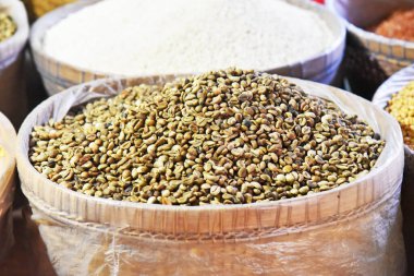 Marketteki bambu sepetinin üzerinde yeşil kahverengi renkli taze kahve çekirdekleri.