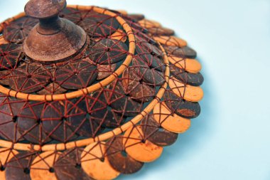 Sepet kapağı, el yapımı hindistan cevizi kabuğundan, kahverengi renkli arka planda izole edilmiş, el yapımı ürün konsepti ve toprak dostu.