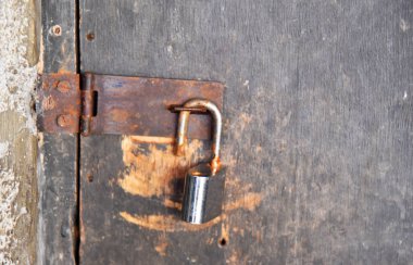 Ev kapısına asma kilit takıldı. Kirli ve paslı durumda.