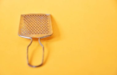 Sarı arka planda izole edilmiş peynir dilimleyici.