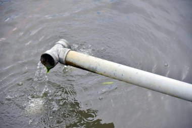 Balık havuzunda su akan borular.