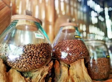 Kahve çekirdekleri cam kavanoza konur, yakın plan.