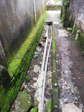 Kuru kanalda drenaj boruları olan küçük bir sokak.