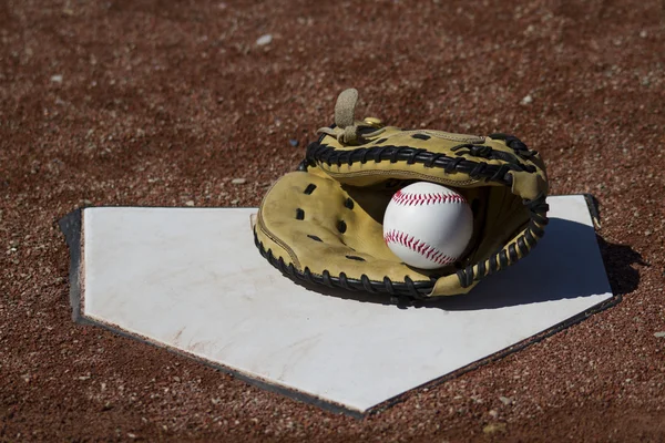 Baseball Catchers Mitt com uma bola de beisebol branco em Webbing na placa Home — Fotografia de Stock