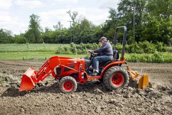 Fermier plus âgé Tilling son jardin avec un tracteur 4x4 compact — Photo