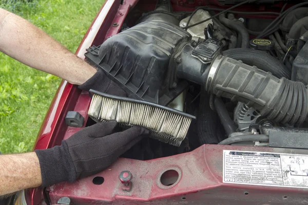 Um mecânico substituindo um filtro de ar sujo em um caminhão — Fotografia de Stock