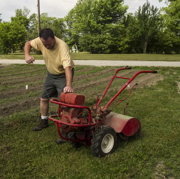 Agricultor orgánico comenzando un viejo cultivador de jardín —  Fotos de Stock