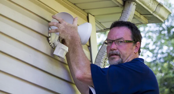 Electrician Putting Up A Motion Detector Light — Stock Photo, Image