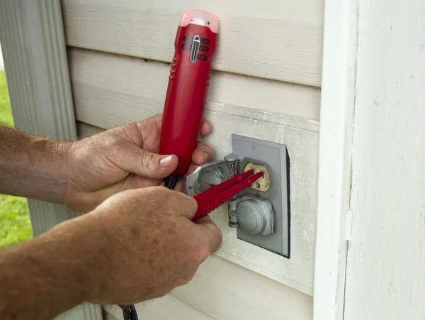 Electricista probando un enchufe eléctrico exterior — Foto de Stock